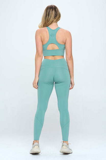 A woman stands facing away from the camera, showcasing the mint green Harmony Activewear Set. The high-stretch fabric sports bra and high-waist leggings perfectly complement her long blonde hair. She finishes the look with white sneakers against a plain white background.