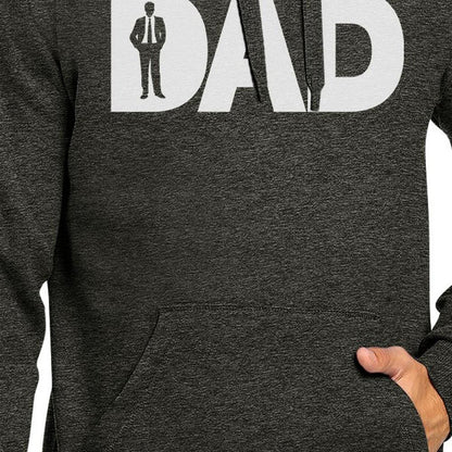 Close-up of a person wearing a Working Dad Graphic Hoodie. The "A" is shaped like a necktie, and there is a silhouette of a man in a suit inside the letter "D," perfect for Father's Day. The person's left hand rests in the front pocket of this stylish working dad attire.