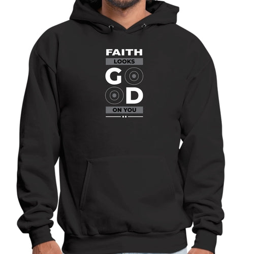 A person is wearing a premium fabric black hoodie with the text "FAITH LOOKS GOOD ON YOU" printed on the front in white and light grey. The "GOOD" features two circular elements resembling vinyl records as the "O" letters, making this Faith Looks Good Graphic Hoodie a stylish unisex fit.