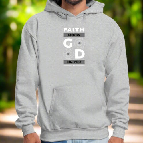 A person wears a light gray Faith Looks Good Graphic Hoodie with the text "FAITH LOOKS GOOD ON YOU" printed vertically. The word "GOOD" features two stylized 'O's resembling vinyl records. With hands in the hoodie pocket, only the torso and part of the arms are visible.